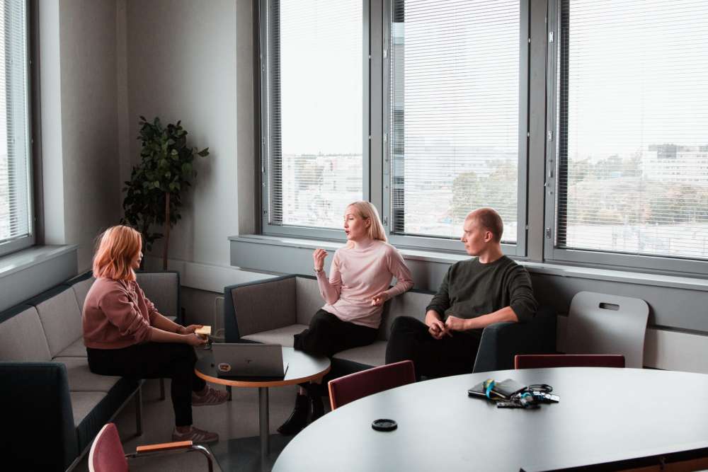 Three employees engage in a meeting in a bright modern office