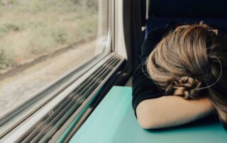 A woman appears distressed as she experiences menopause symptoms while on a train