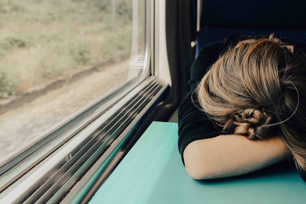 A woman appears distressed as she experiences menopause symptoms while on a train