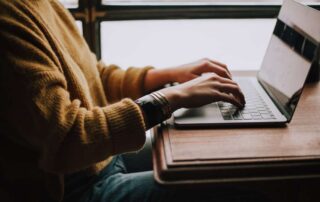 A man sits at his desk and types on his computer