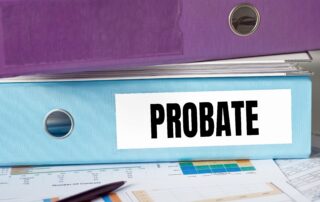 two folders stacked on top of each other, the one on the bottom has a sticker that says probate