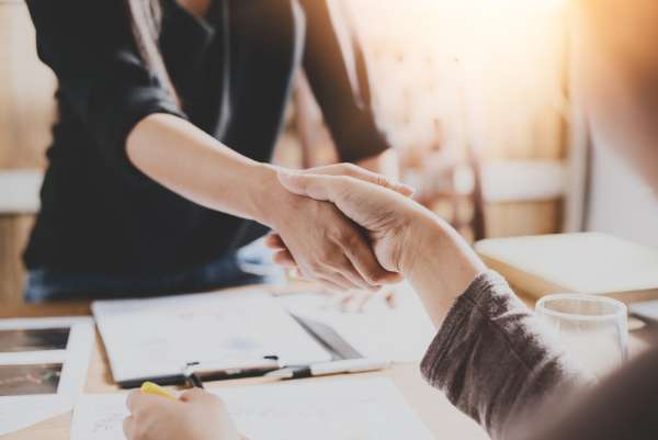 A landlord and tenant shake hands after resolving a dispute