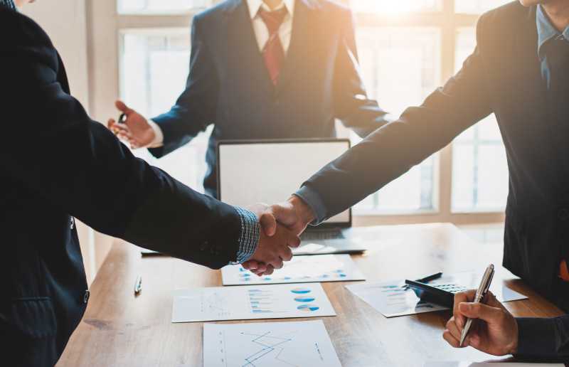 Two businessmen shake hands after resolving a dispute