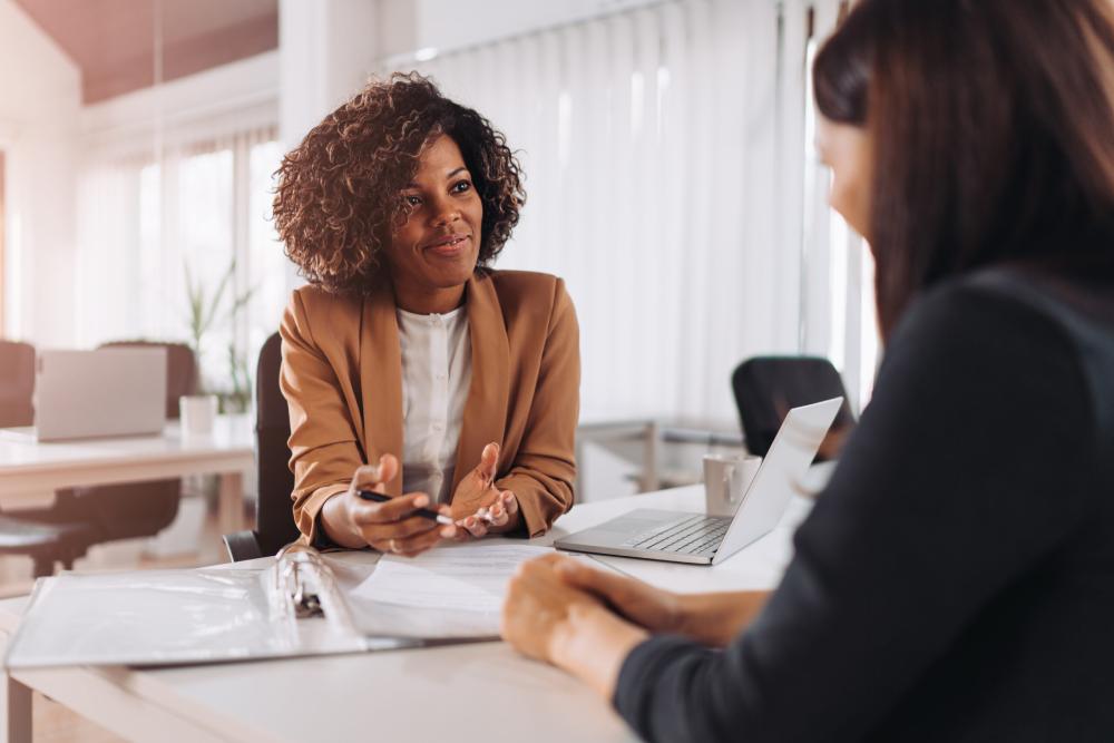 A smiling female solicitor gives legal advice to a client during a consultation