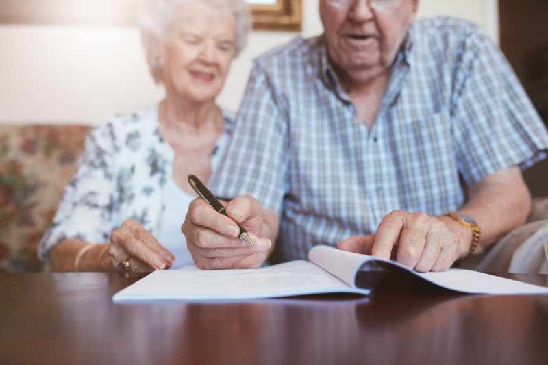 An elderly couple write their Wills in their home