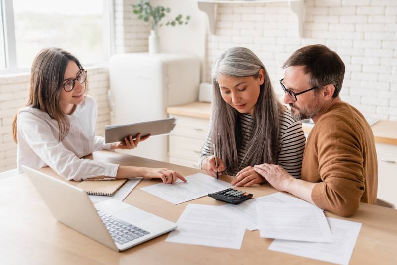 A middle aged couple consult with a commercial litigation solicitor