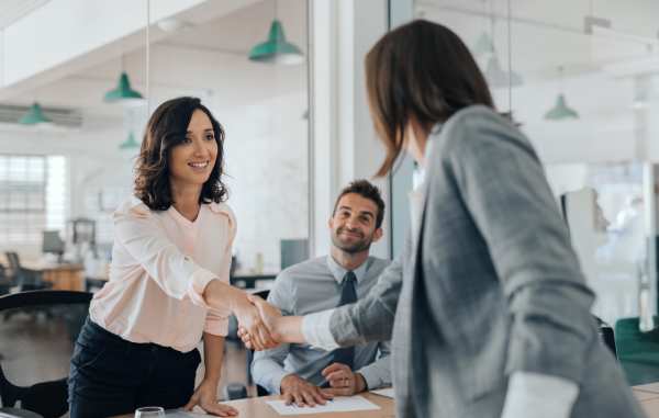 Two businesswomen shake hands after resolving a dispute