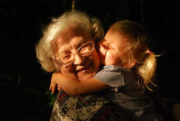 A grandmother hugs her granddaughter