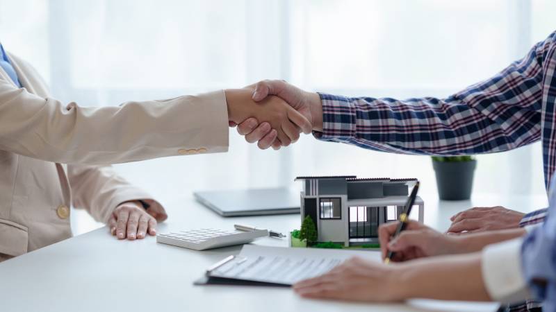 A pair of will executors shake hands after resolving their differences during a legal consultation