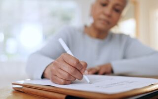 A woman signs a financial consent order form